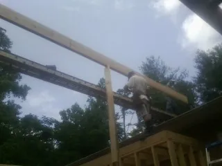 Carpenter setting a ridge beam over a new addition frame — Ice Dam Removal by Roofing Brothers in Ione